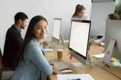 a girl working in desktop with her colleagues